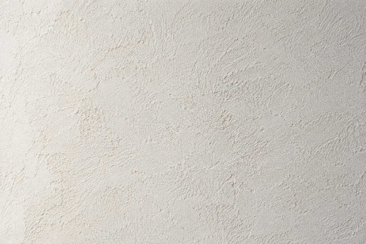 Gros plan de la texture mate d’un enduit à la chaux clair — illustration