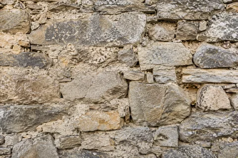 Pierres irrégulières et joints usés d’un mur ancien avant rénovation — illustration